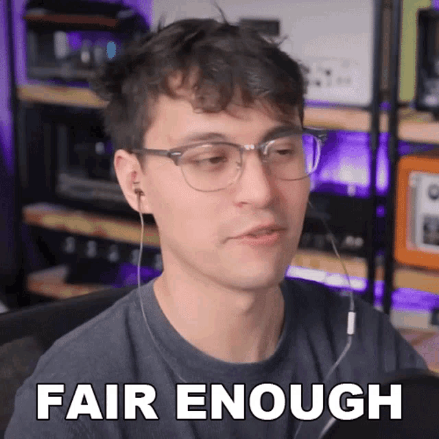a man wearing glasses and ear buds says " fair enough "