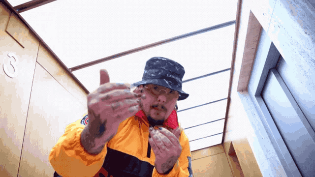 a man wearing a hat that says lacoste is giving a middle finger