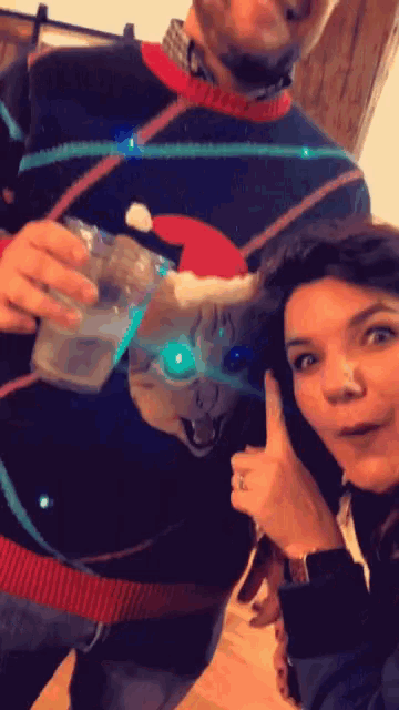 a woman giving a thumbs up next to a man wearing a sweater with a dog on it