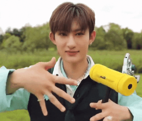 a young man is holding a yellow object in his hands and making a funny face .