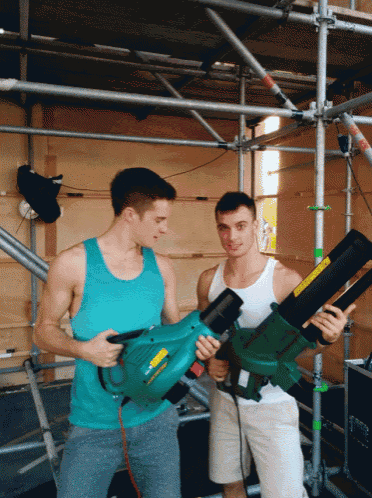 two men standing next to each other holding a green blower that says ' stihl ' on the side