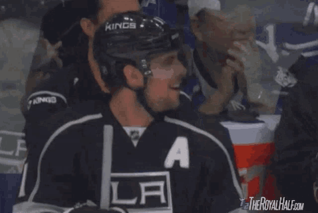 a hockey player is smiling in front of a gatorade cooler ..