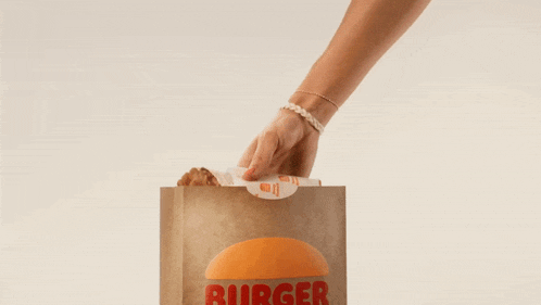 a person is taking a wrap out of a burger bag