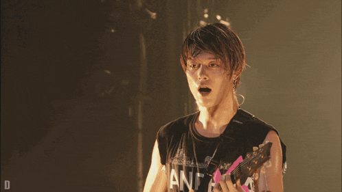 a man playing a guitar with a shirt that says and on it