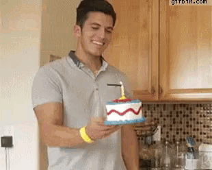 a man is holding a cake with a candle on it