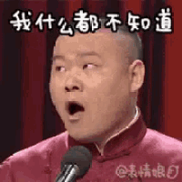a man is standing in front of a microphone and making a surprised face .