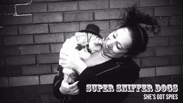 a woman holding a small dog with the words super snifter dogs she 's got spies