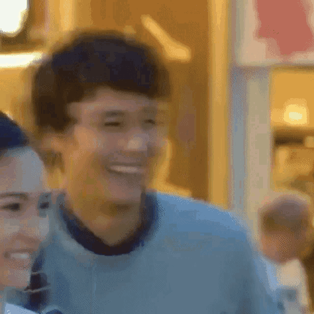 a man and a woman are smiling and hugging each other .