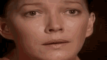 a close up of a woman 's face with a surprised expression .