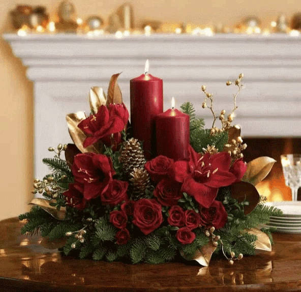 a christmas centerpiece with red candles and red flowers