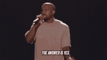 a man is singing into a microphone with the words the answer is yes written on it