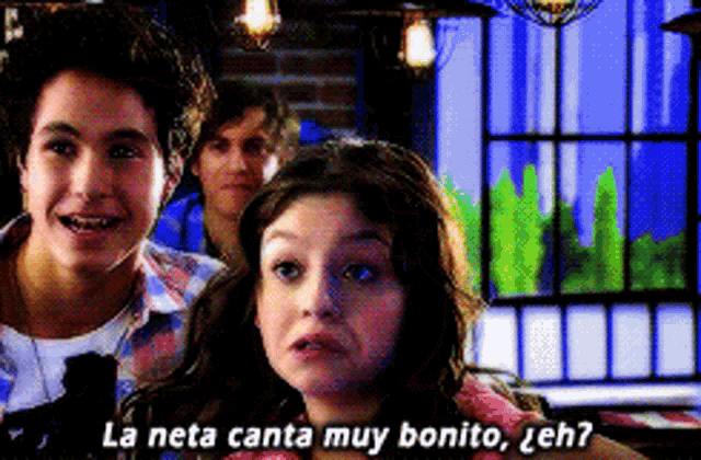 a group of people are standing in front of a window with the words la neta canta muy bonito written above them