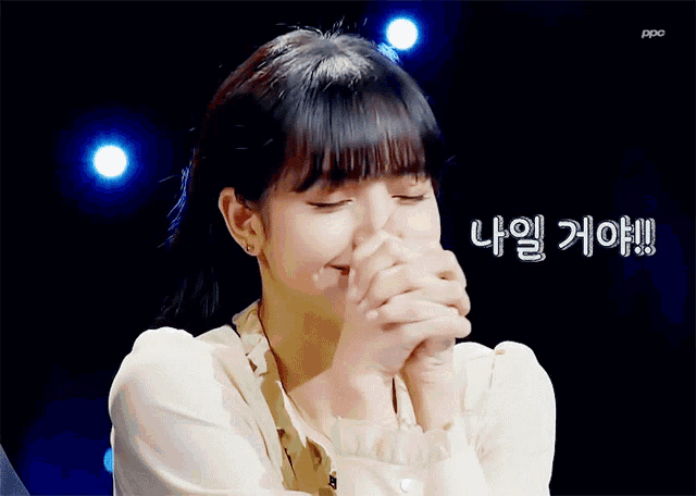 a woman covering her face with her hands with a foreign language written on the bottom