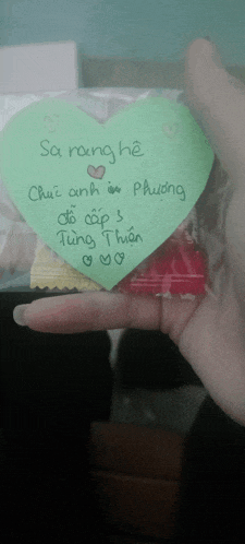 a person is holding a heart shaped card that says sa rang he on it