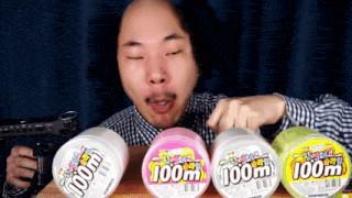 a bald man with a wig and mustache is eating three containers of 100m toothpaste