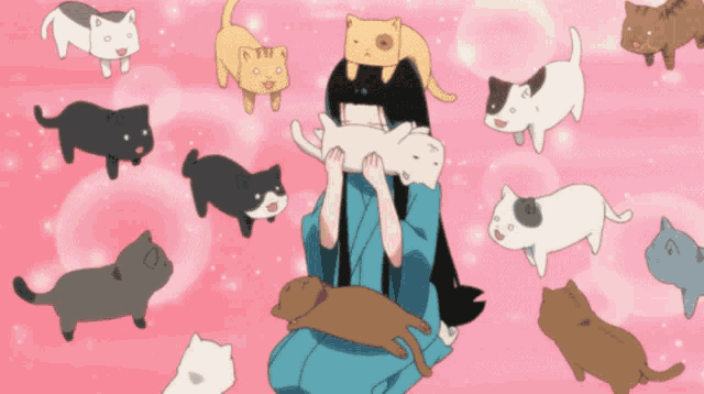 a girl is surrounded by a bunch of cats one of which is laying on her head