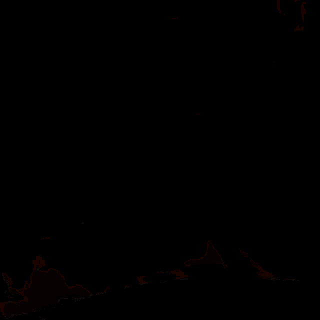 a woman in a red dress is laying on her stomach on the floor in a dark room .