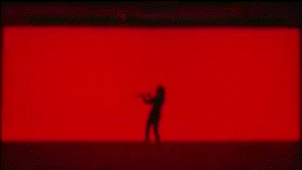 a man is looking out of a window in a red room .