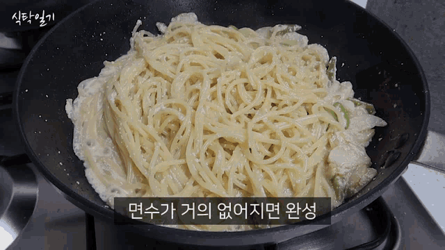 a frying pan filled with noodles and sauce with a foreign language caption