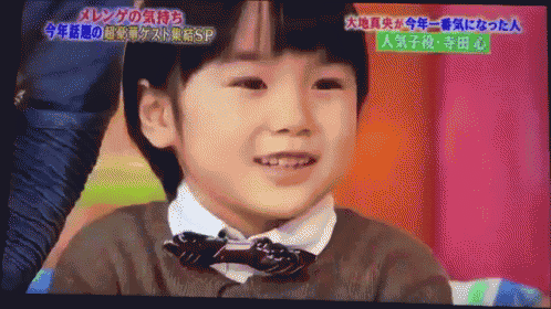 a young boy in a bow tie is on a television screen