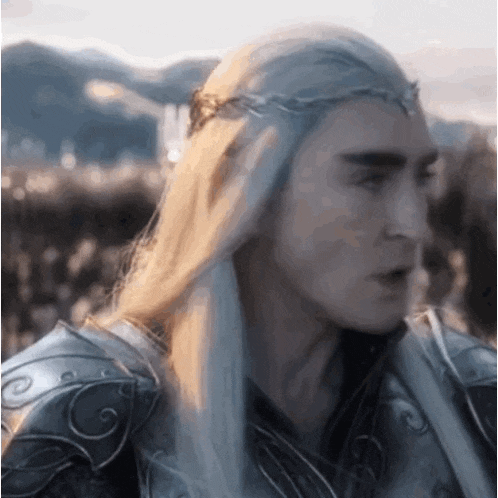 a man with long white hair is wearing armor and a crown .