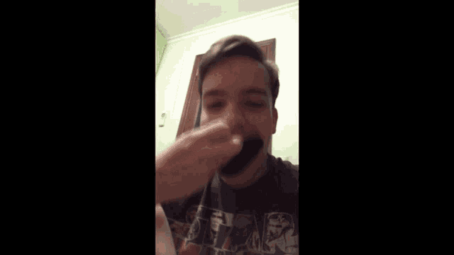 a young man wearing a star wars shirt eating something