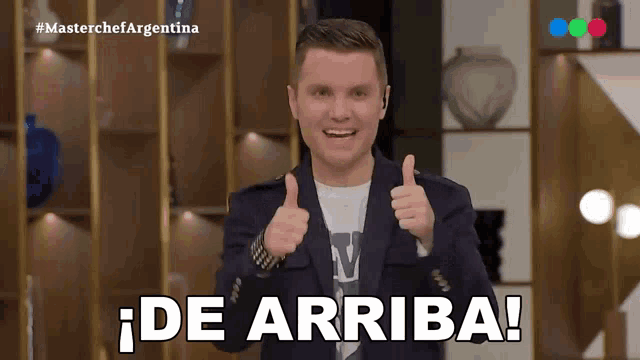 a man giving a thumbs up in front of a sign that says masterchef argentina