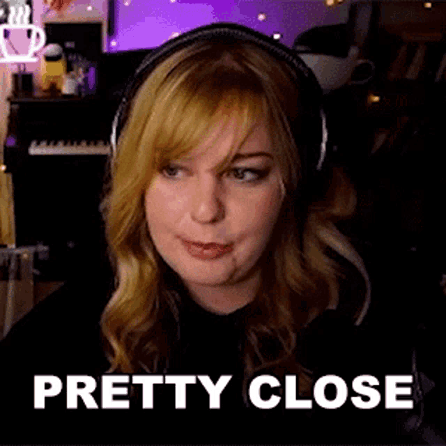 a woman wearing headphones and a black shirt is sitting in front of a computer screen .