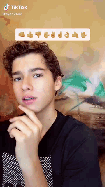 a young man in a black shirt with a tiktok sticker on his face