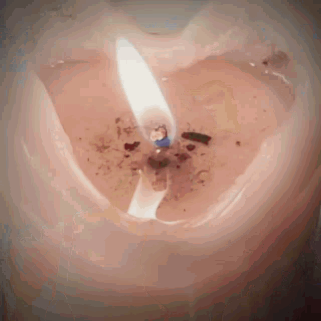 a close up of a pink candle with a blue flame