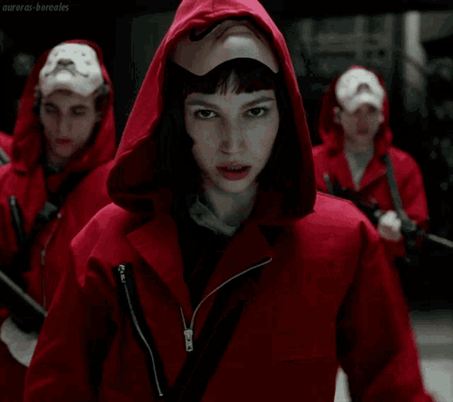 a man in a red hooded jacket has a mustache on his face and a white glove on his hand