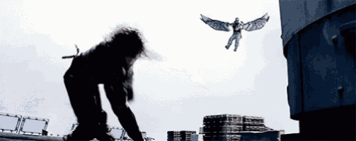 a man with wings is flying in the air while another man is kneeling down