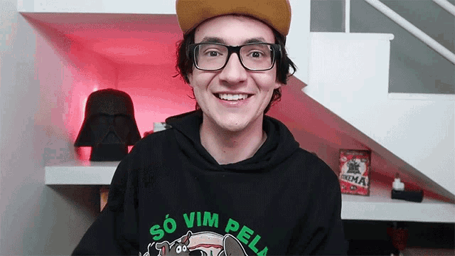 a man wearing glasses and a black sweatshirt that says so vim pela