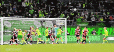 a soccer game is being played in front of a sign that says ' uberachung ' on it