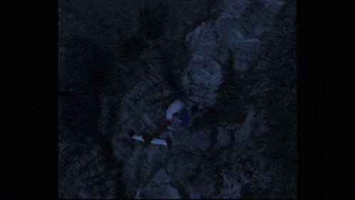 a person is standing in front of a large explosion in the dark .