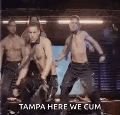 a group of men are dancing on a stage in a club .