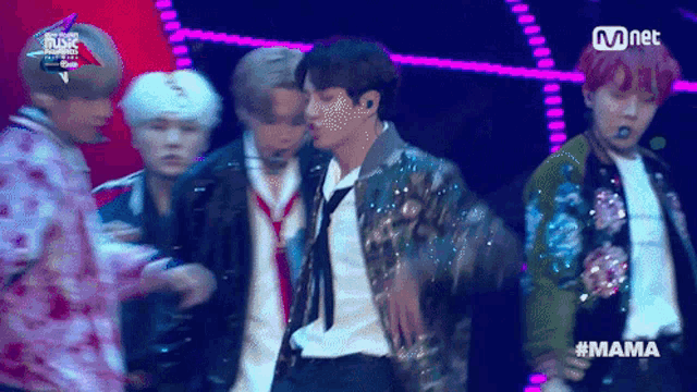 a group of young men are performing on a stage with the hashtag mama