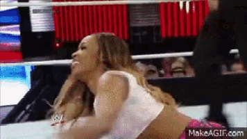 a woman is kneeling down in a wrestling ring with a makeagif.com watermark