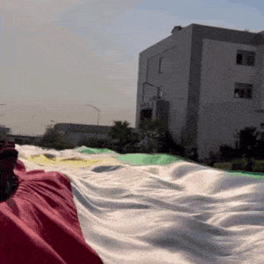 a large flag is being held in front of a large building