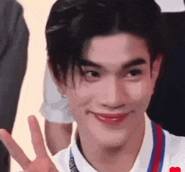a close up of a person giving a peace sign .