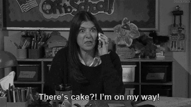 a woman is talking on a cell phone and says there 's cake ? i 'm on my way