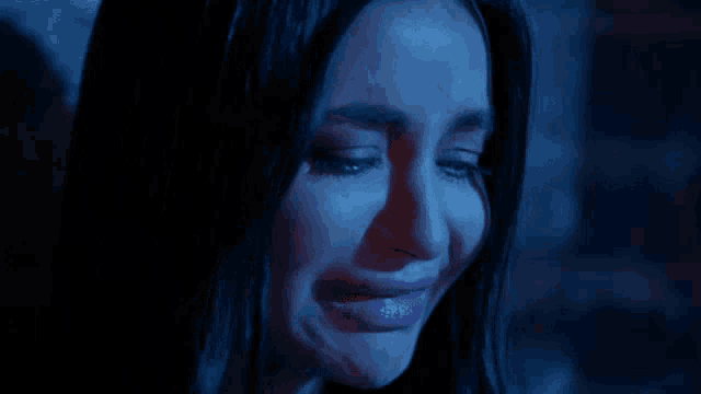 a close up of a woman 's face with tears coming out of her eyes