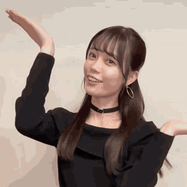 a woman wearing a choker and earrings is making a funny face with her hands in the air