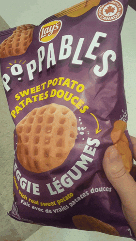 a person is holding a bag of lays poppables sweet potato
