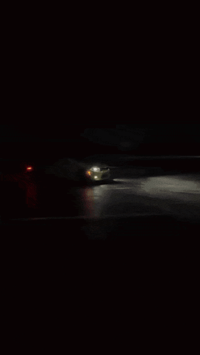 a blurry photo of a street at night with a red light in the background