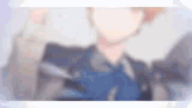 a blurry picture of a man in a suit and tie with a blue bow tie .