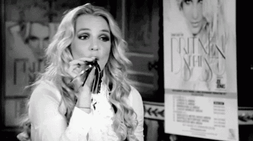 a black and white photo of a woman blowing a whistle .