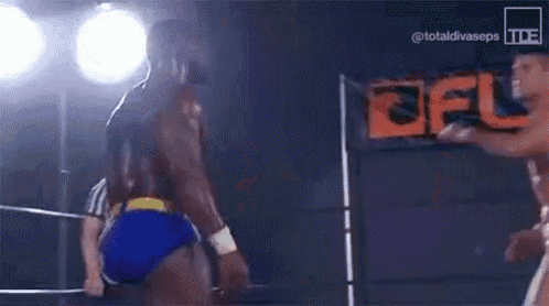two men are wrestling in a wrestling ring .