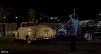 a yellow car is parked next to a black car at night