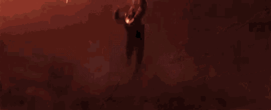 a man is flying through the air in front of a fireball .